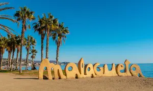Słoneczne andaluzja plaże z palmami i napisem "Malagueta". Idealne miejsce na relaks.