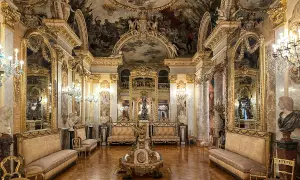 Złocone wnętrze pałacowe, przypominające salę w madryckich muzeach, z malowidłami na suficie i bogatymi meblami.