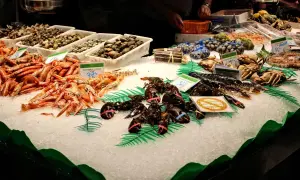 Świeże owoce morza na lodzie w La Boqueria: krewetki, homary, kraby i małże.