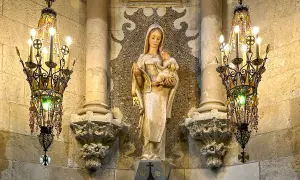 Figurka Matki Boskiej z Dzieciątkiem, otoczona ozdobnymi żyrandolami, to jeden z wielu detali, które warto odkryć w Sagrada Familia. Ciekawostki architektoniczne zachwycają.