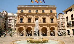 Fontanna na placu przed ratuszem w Castellón de la Plana, Walencja. Flagi Hiszpanii i regionu Walencji powiewają na dachu.