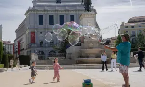 Dzieci gonią bańki mydlane na placu w Madrycie, to świetne atrakcje dla dzieci.