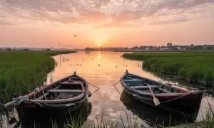 Dwa łodzie kołyszą się na spokojnej wodzie Albufera Valencia o zachodzie słońca, otoczone zielonymi polami ryżowymi.