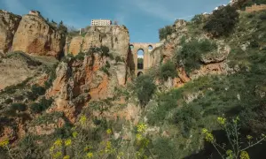 Mosty w Ronda, Andaluzja najpiękniejsze miejsca. Imponująca architektura na tle skalistych zboczy, porośniętych zielenią i żółtymi kwiatami.
