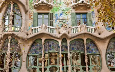 Fasada Casa Batlló w Barcelonie, z falującymi formami, mozaikami i kolorowymi witrażami, jakby wyjęta z baśni.