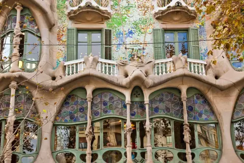 Fasada Casa Batlló w Barcelonie, z falującymi formami, mozaikami i kolorowymi witrażami, jakby wyjęta z baśni.