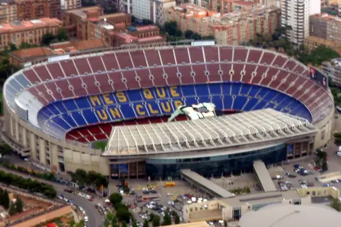 Camp Nou, stadion o imponującej pojemności, z napisem "Més que un club" na trybunach.