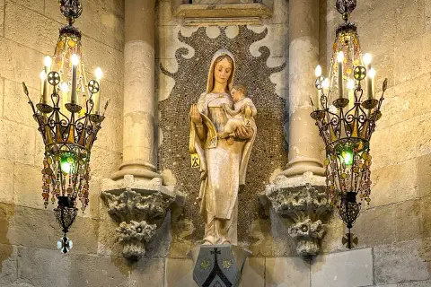 Figurka Matki Boskiej z Dzieciątkiem, otoczona ozdobnymi żyrandolami, to jeden z wielu detali, które warto odkryć w Sagrada Familia. Ciekawostki architektoniczne zachwycają.