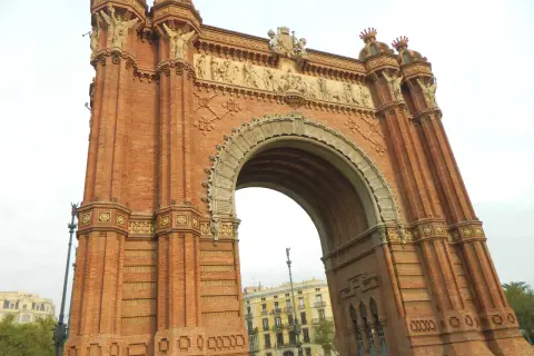 Majestatyczny łuk triumfalny Barcelona, zbudowany z cegły, z bogatymi zdobieniami i rzeźbami.