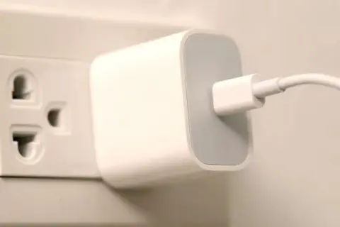 Ładowarka podłączona do gniazdka elektrycznego. W Hiszpanii takie gniazdka są powszechne.