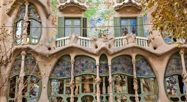 Fasada Casa Batlló w Barcelonie, z falującymi formami, mozaikami i kolorowymi witrażami, jakby wyjęta z baśni.