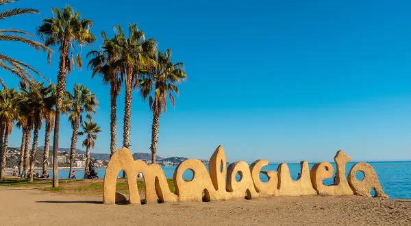 Słoneczne andaluzja plaże z palmami i napisem "Malagueta". Idealne miejsce na relaks.