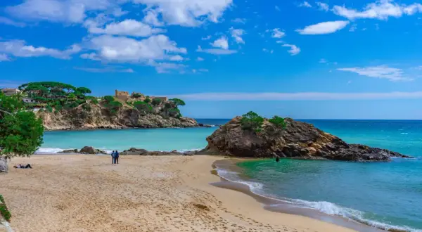 Piękna plaża z turkusową wodą i skalistymi wysepkami. Idealne miejsce na relaks i odkrywanie uroków Costa Brava.