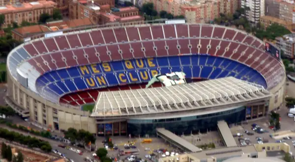 Camp Nou, stadion o imponującej pojemności, z napisem "Més que un club" na trybunach.