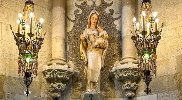 Figurka Matki Boskiej z Dzieciątkiem, otoczona ozdobnymi żyrandolami, to jeden z wielu detali, które warto odkryć w Sagrada Familia. Ciekawostki architektoniczne zachwycają.