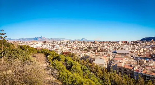 Widok na miasto Alicante z zielonymi wzgórzami. Idealne miejsce na wakacyjne alicante noclegi.