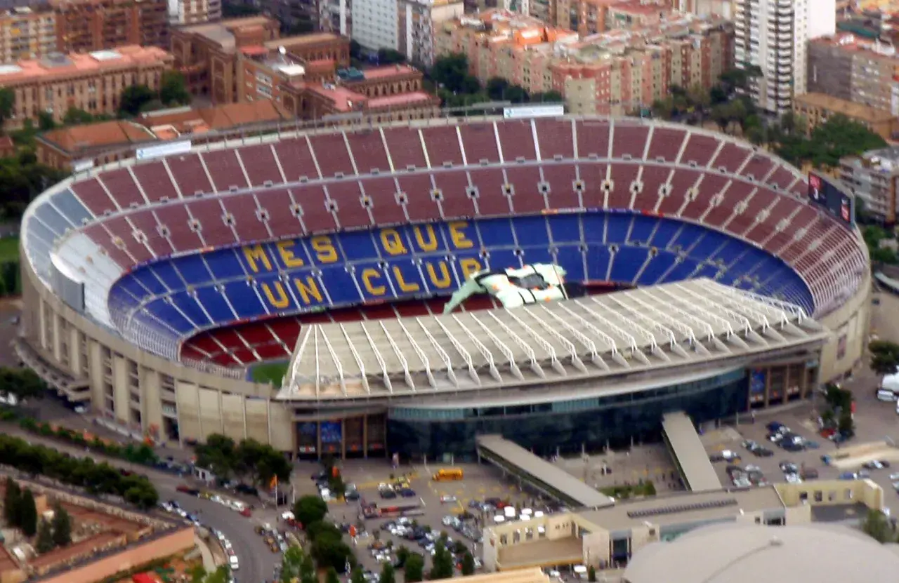 Camp Nou, stadion o imponującej pojemności, z napisem "Més que un club" na trybunach.