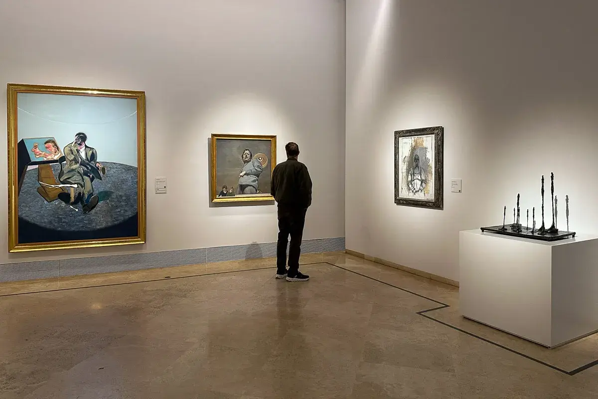 W muzeum Thyssen-Bornemisza zwiedzający kontempluje dzieła sztuki, w tym portret Bacona.