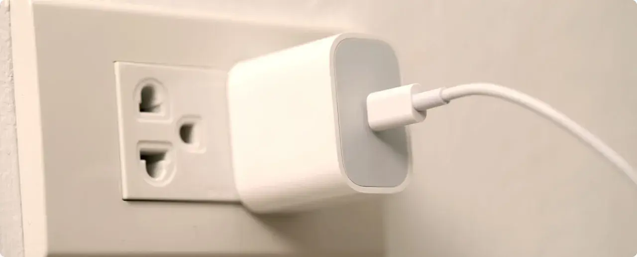 Ładowarka podłączona do gniazdka elektrycznego. W Hiszpanii takie gniazdka są powszechne.