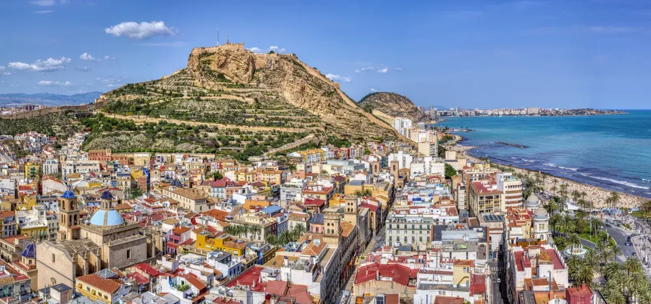 Alicante w lutym: słoneczna pogoda zachęca do spacerów po plaży i zwiedzania zamku Santa Bárbara. Widok na miasto i morze.