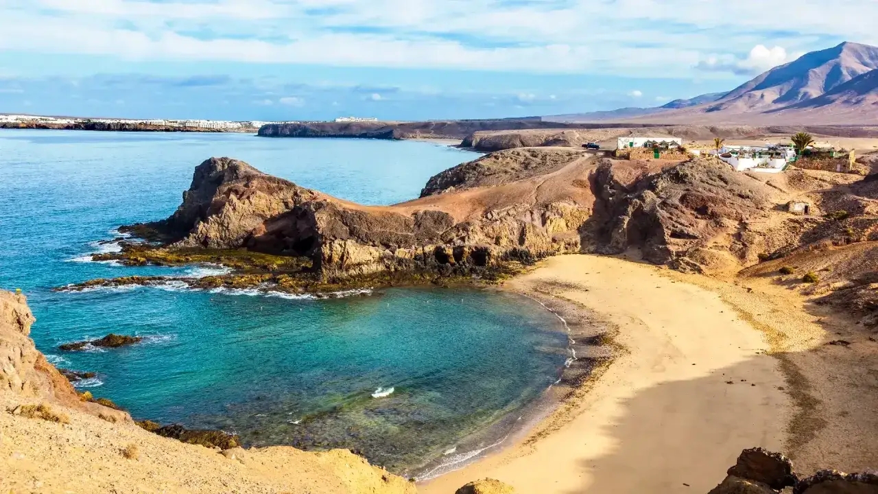 Plaża Papagayo na Lanzarote, z turkusową wodą, skalistymi klifami i piaszczystym wybrzeżem, zaprasza do odpoczynku.