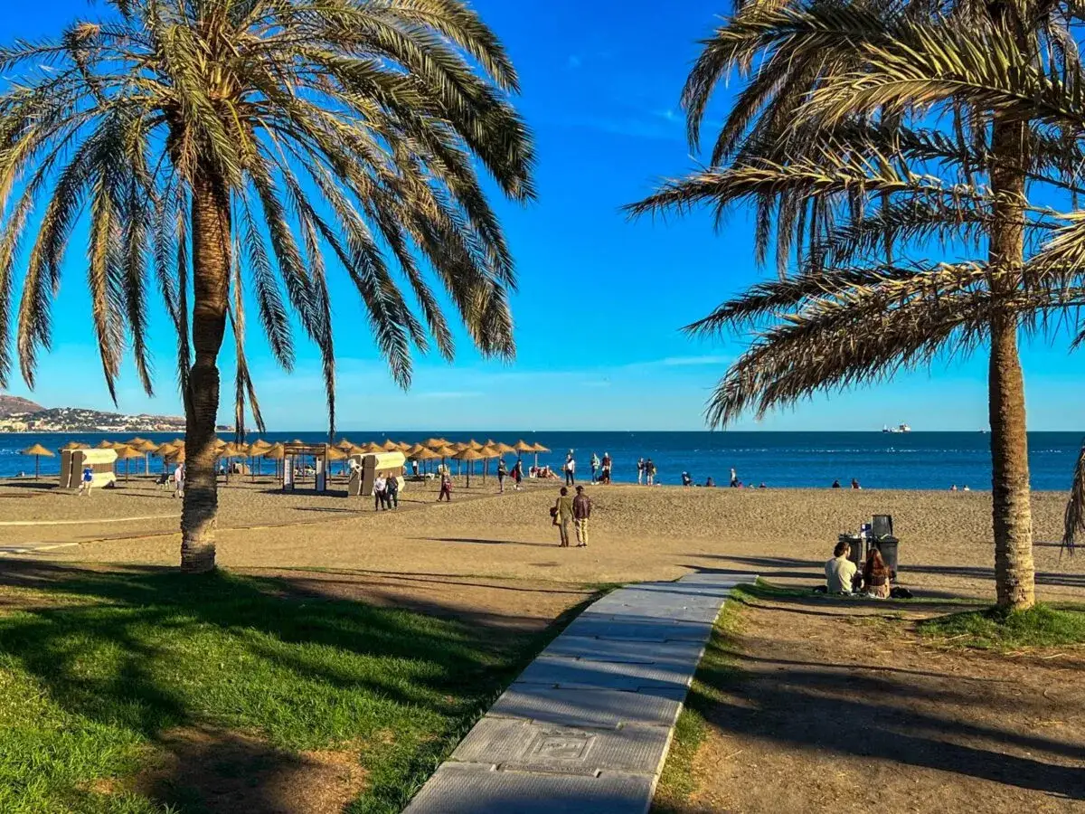 Malaga słynie z pięknych plaż, palm i błękitnego morza. Słoneczny dzień zachęca do odpoczynku na piasku.