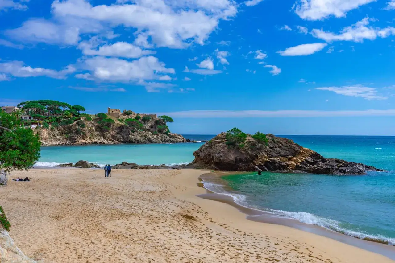 Piękna plaża z turkusową wodą i skalistymi wysepkami. Idealne miejsce na relaks i odkrywanie uroków Costa Brava.