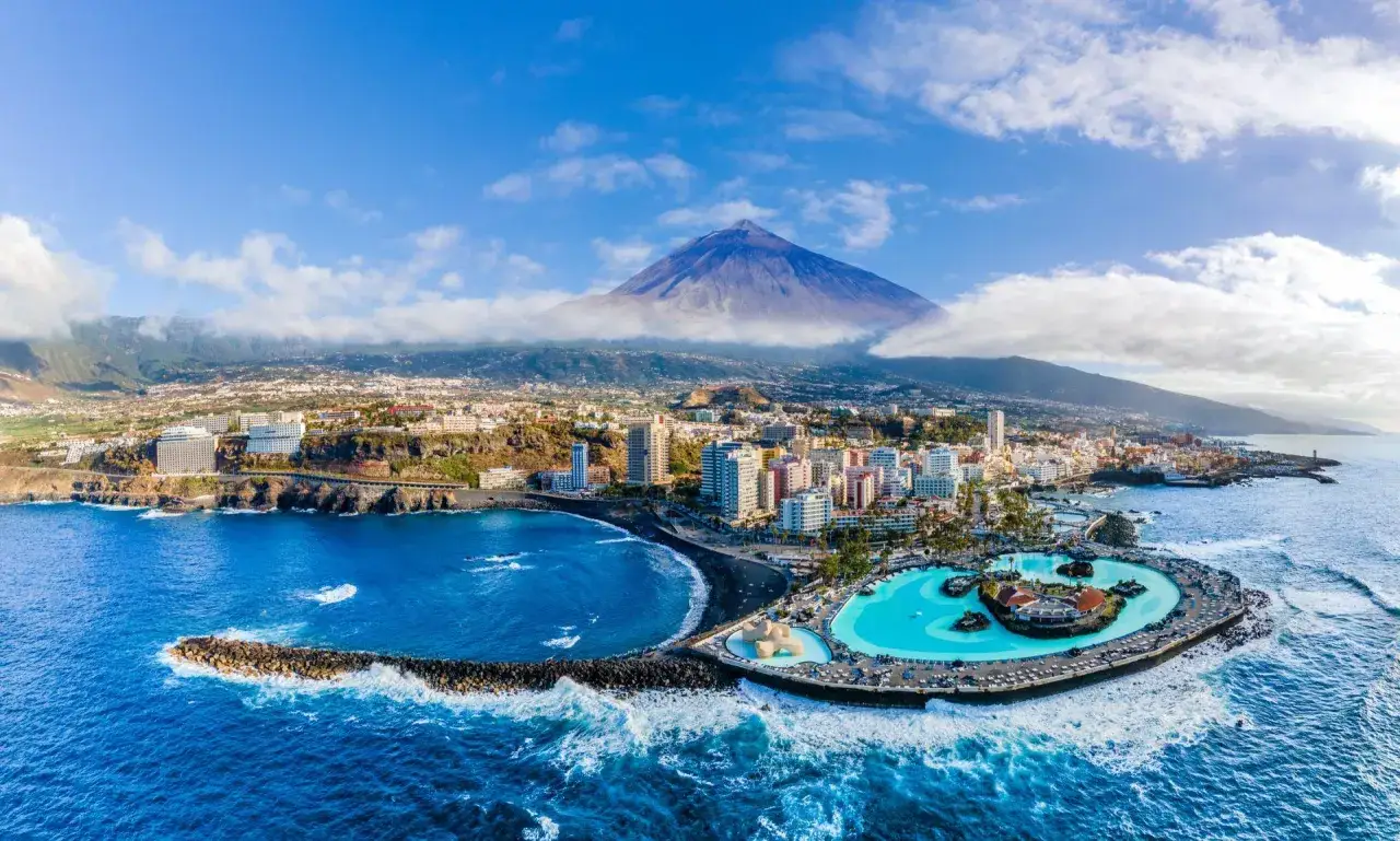 Widok na miasto z basenami i wulkanem w tle. Czy to Teneryfa czy Gran Canaria?