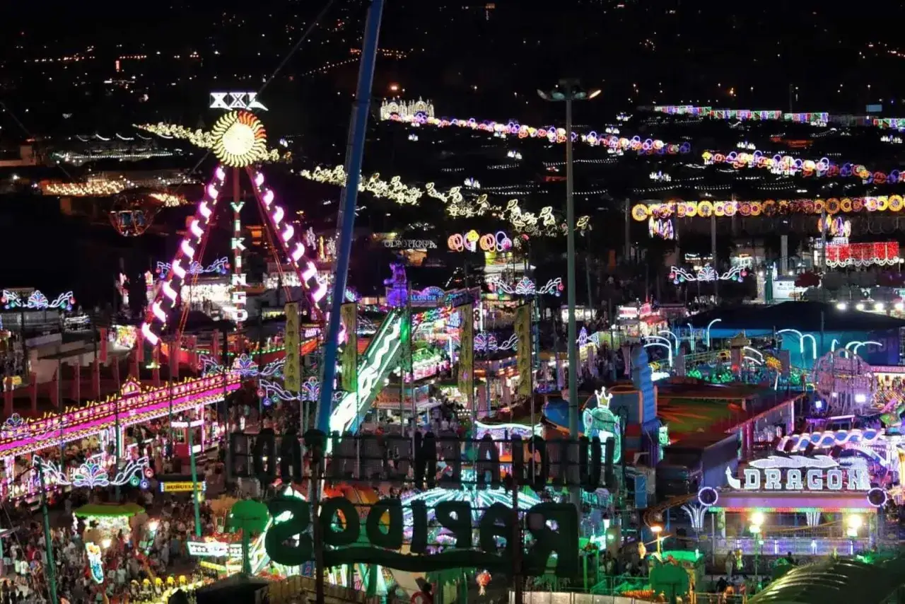 Nocna feria w Maladze tętni życiem. Kolorowe światła, karuzele i tłumy ludzi tworzą magiczną atmosferę.