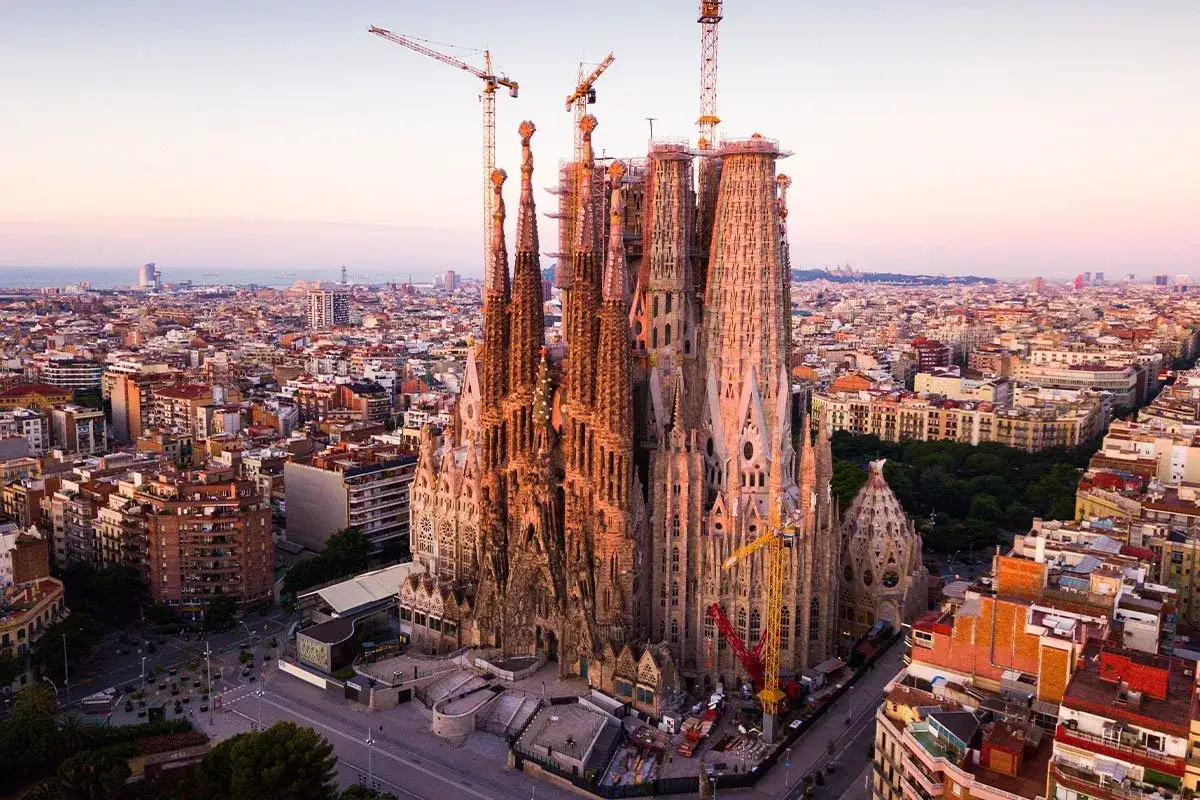 Niesamowite antonio gaudi budowle, Sagrada Familia w Barcelonie, wznosi się nad miastem, otoczona dźwigami budowlanymi.