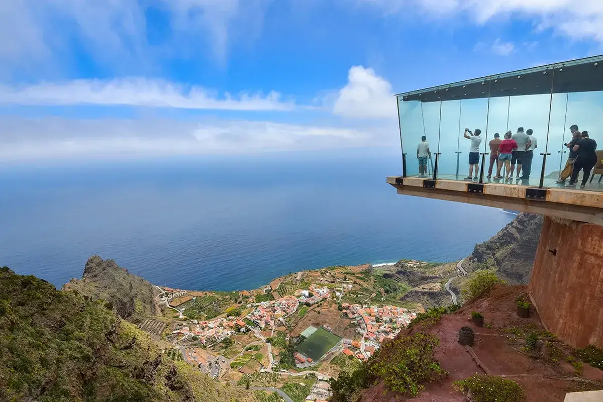 Widok z przeszklonego tarasu na La Gomera. Turyści podziwiają panoramę oceanu i urokliwej wioski poniżej. Niezapomniane la gomera atrakcje.