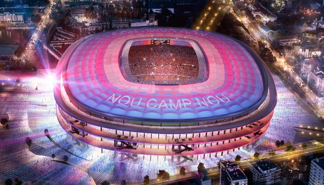 Nocny widok stadionu Camp Nou, oświetlonego na różowo i niebiesko. Napis