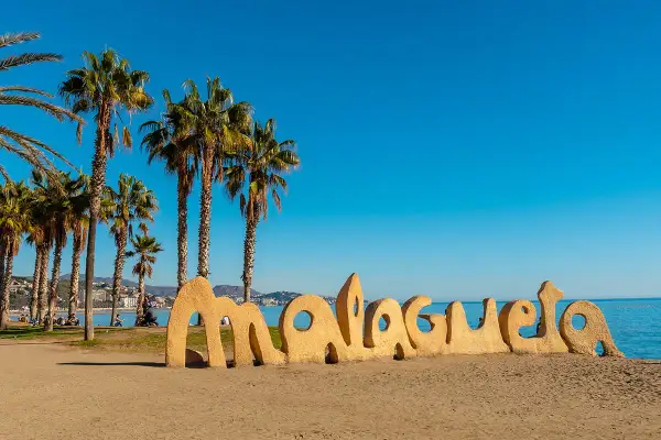 Słoneczne andaluzja plaże z palmami i napisem "Malagueta". Idealne miejsce na relaks.