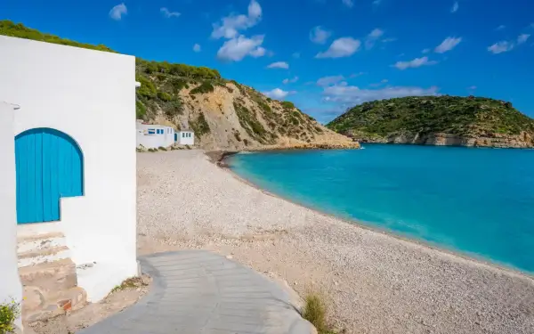 Malownicza plaża w Alicante z białymi domkami i turkusową wodą. Idealne miejsce na relaks.