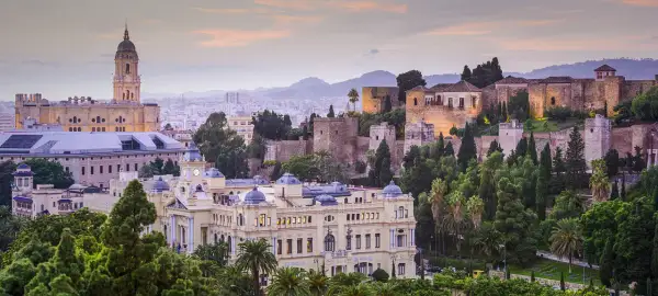 Malaga atrakcje: Katedra, Alcazaba i pałac na wzgórzu, otoczone zielenią i miastem.