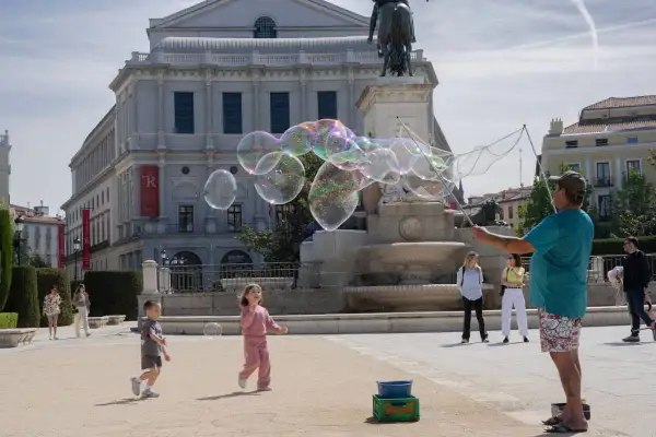 Dzieci gonią bańki mydlane na placu w Madrycie, to świetne atrakcje dla dzieci.