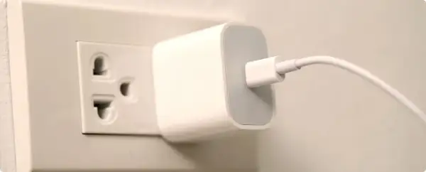 Ładowarka podłączona do gniazdka elektrycznego. W Hiszpanii takie gniazdka są powszechne.