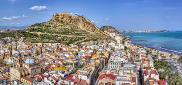 Alicante w lutym: słoneczna pogoda zachęca do spacerów po plaży i zwiedzania zamku Santa Bárbara. Widok na miasto i morze.